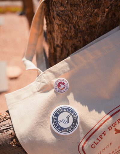 cliffdwellers general store (32) Canvas bag with branded badges beside a log