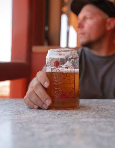 cliffdwellers general store (71) Man holding beer glass in cafe, blurred background