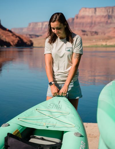 cliffdwellers general store (9) Woman preparing kayak by scenic river and cliffs